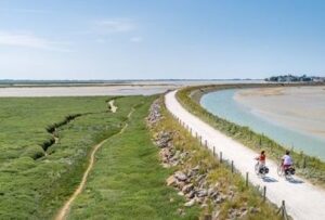 Deux cyclistes sur une piste longeant les marais de la baie de Somme